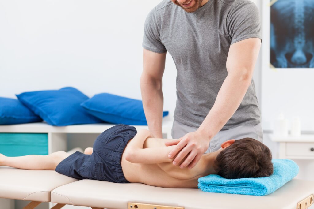 Pediatric chiropractor adjusting child on his side