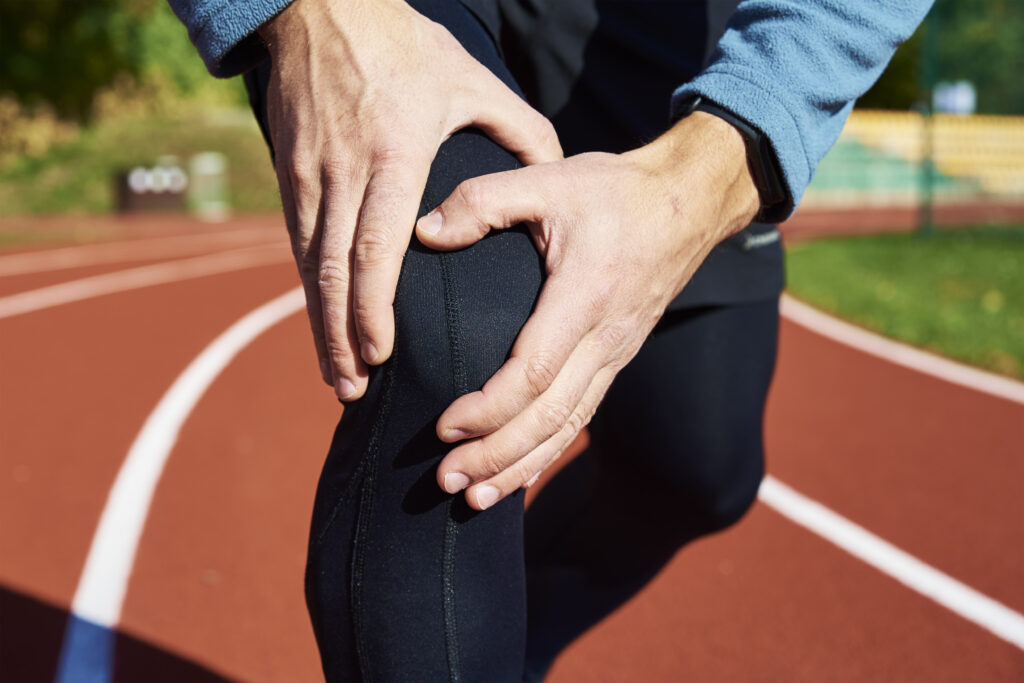 Man on track holding knee