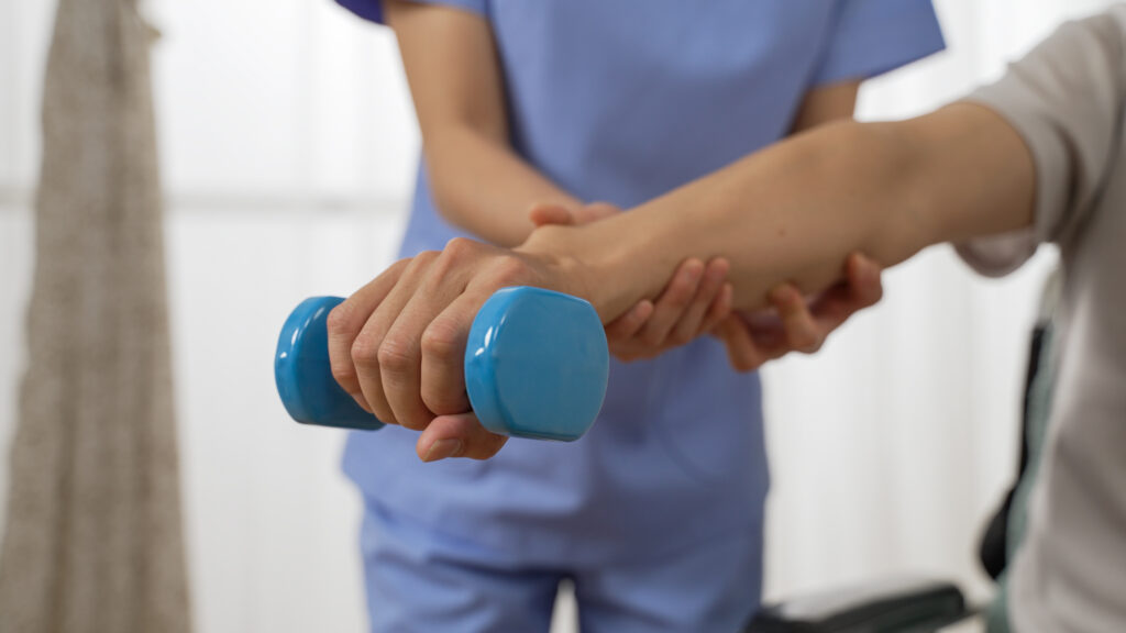 older man lifting a small dumbell in rehabilitation