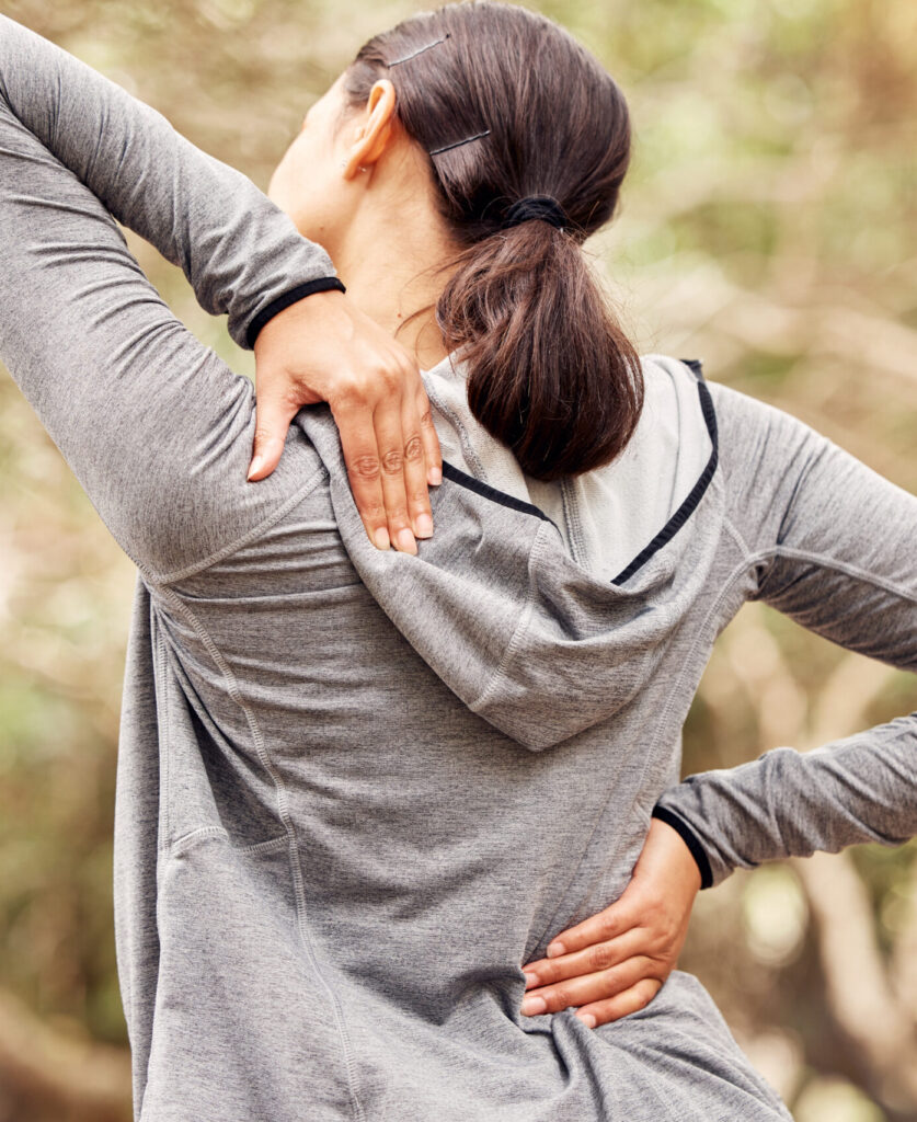 Woman outdoors experiencing back pain