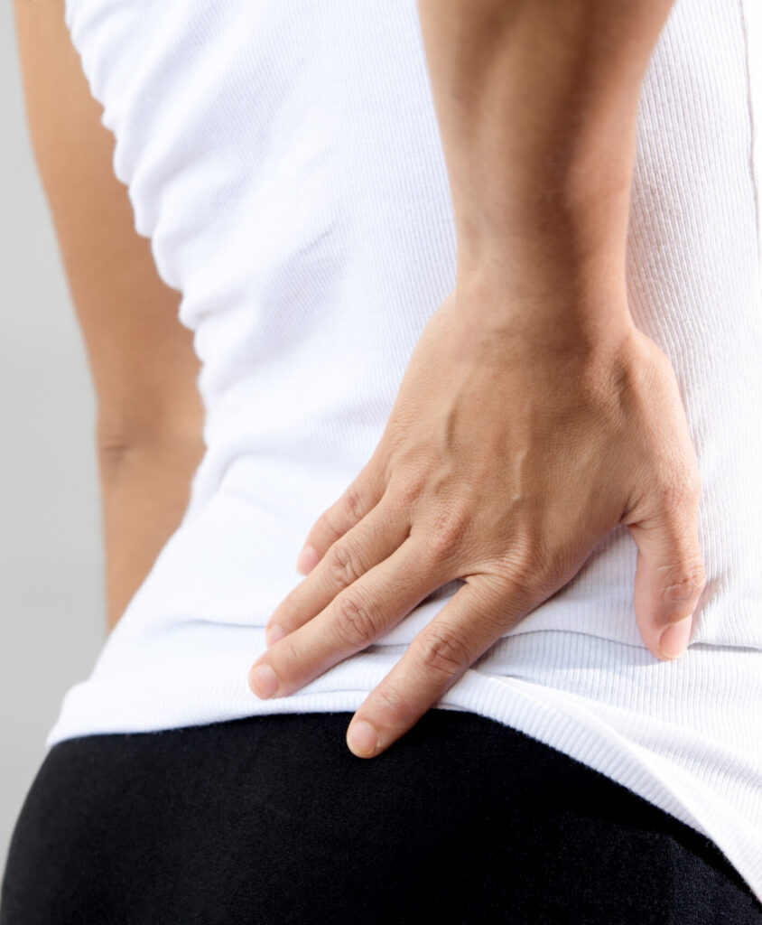 Woman in white shirt with lower back pain