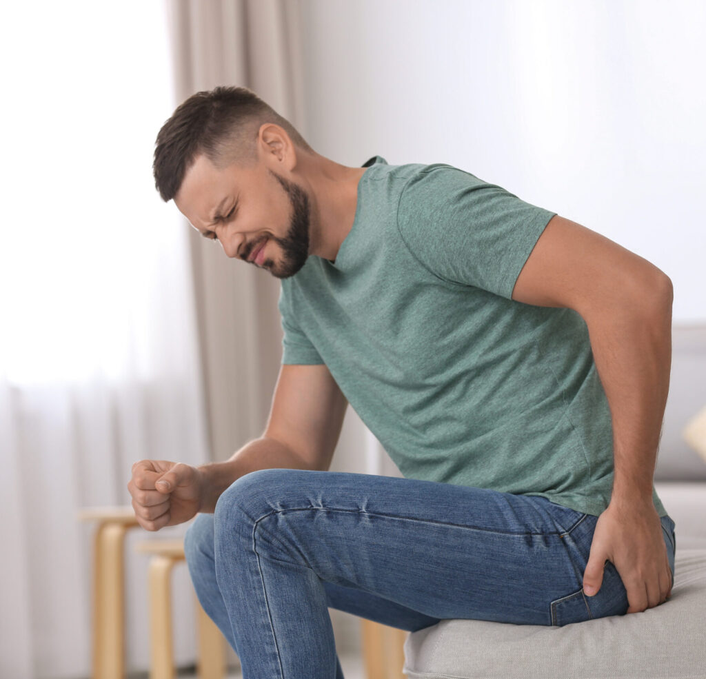 Man sitting on bed with sciatica