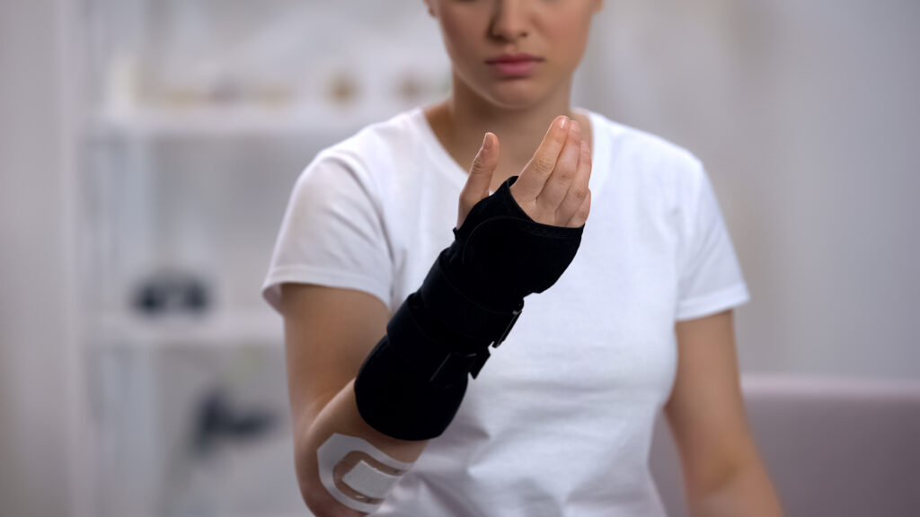 Female athlete with brace on wrist from sports related personal injury