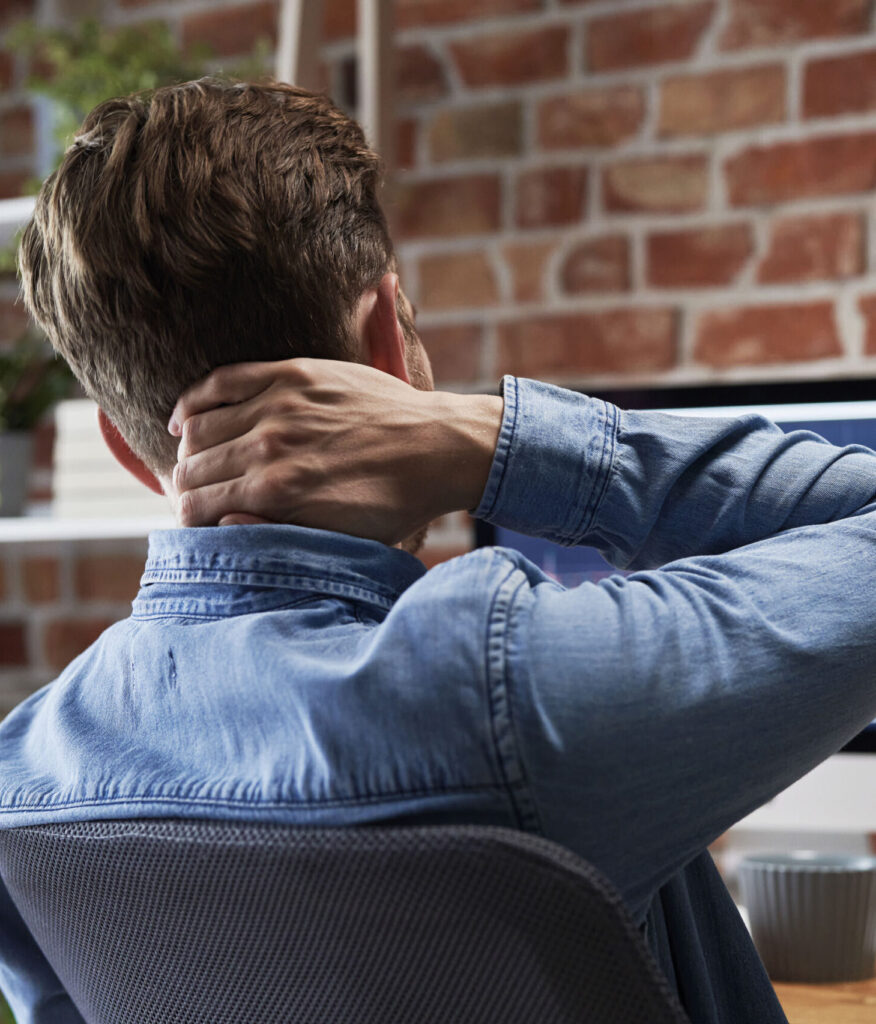 Man working in front of computer with pain in neck